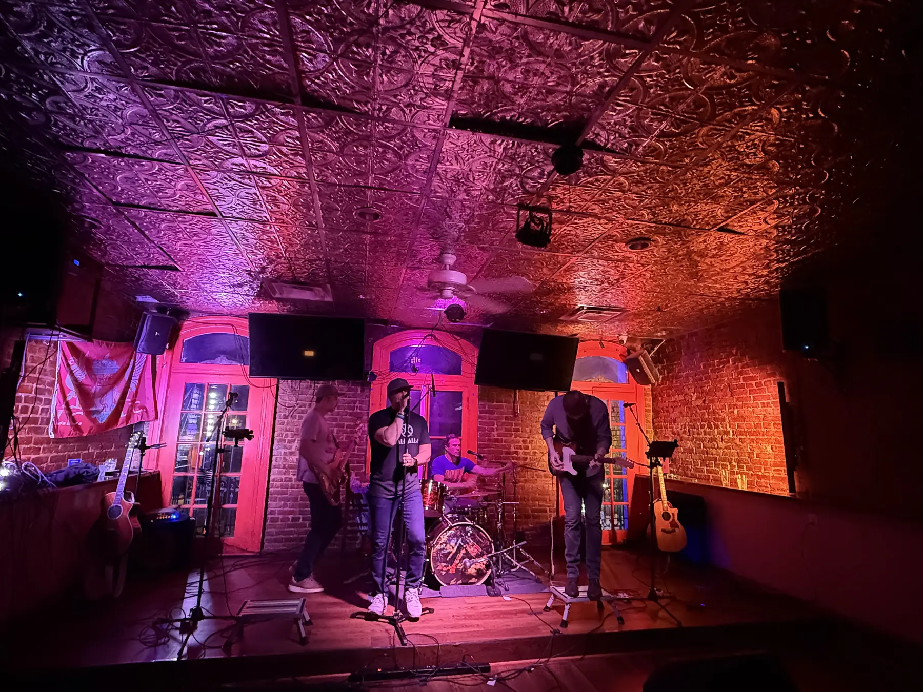 The band performing under purple stage light